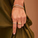 Prong Set Diamond Baguette Ring styled on index finger of model with bracelets and gold ring
