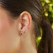 Diamond Sparkle Stud Earring in 14k yellow gold styled in fourth earring hole of model next to diamond teardrop, hummingbird, and trio treasure earrings