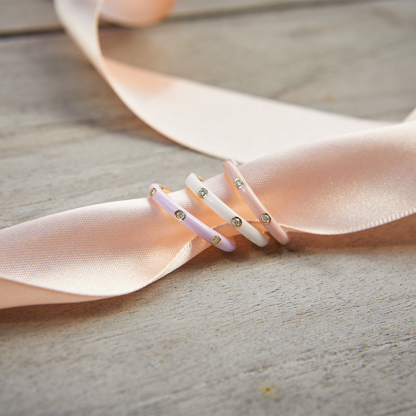 3 Diamond & White Enamel Stack Ring with pink and lavender enamel ring on pink ribbon
