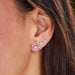 Pink Sapphire & Diamond Trio Cluster Stud Earring in 14k yellow gold styled on first earring hole of model next to two diamond trio earrings
