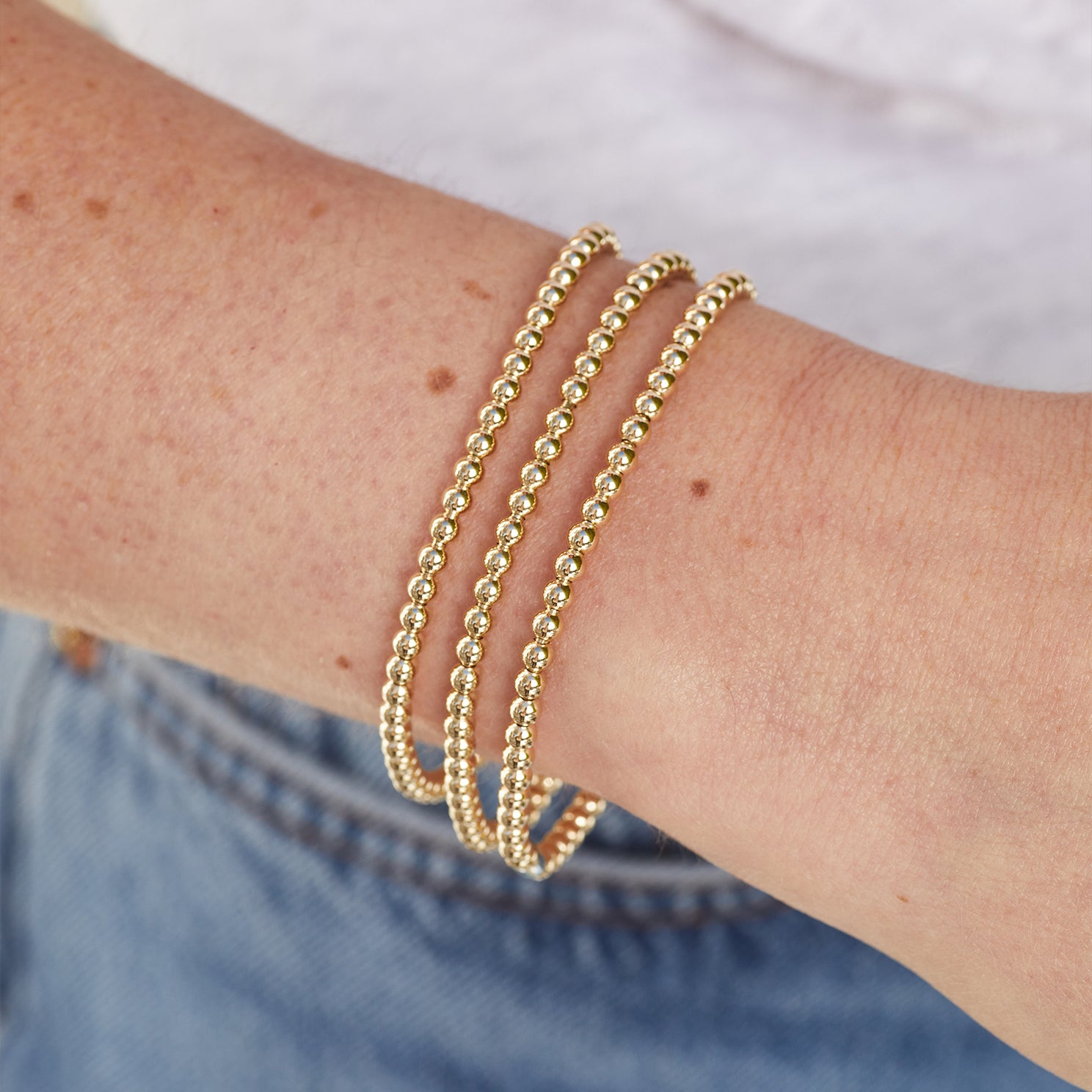 The Ball Bracelet Gift Set in 14k yellow gold styled on wrist of model