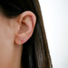 Diamond Mini Cross Stud Earring styled on ear lobe of model