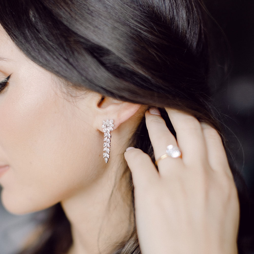 EF Collection pretty lady diamond earrings styled on ear of model and diamond ring styled on ring finger