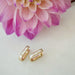 Diamond Baguette Jumbo Lola Hoop Earring in 14k yellow gold next to pink flower