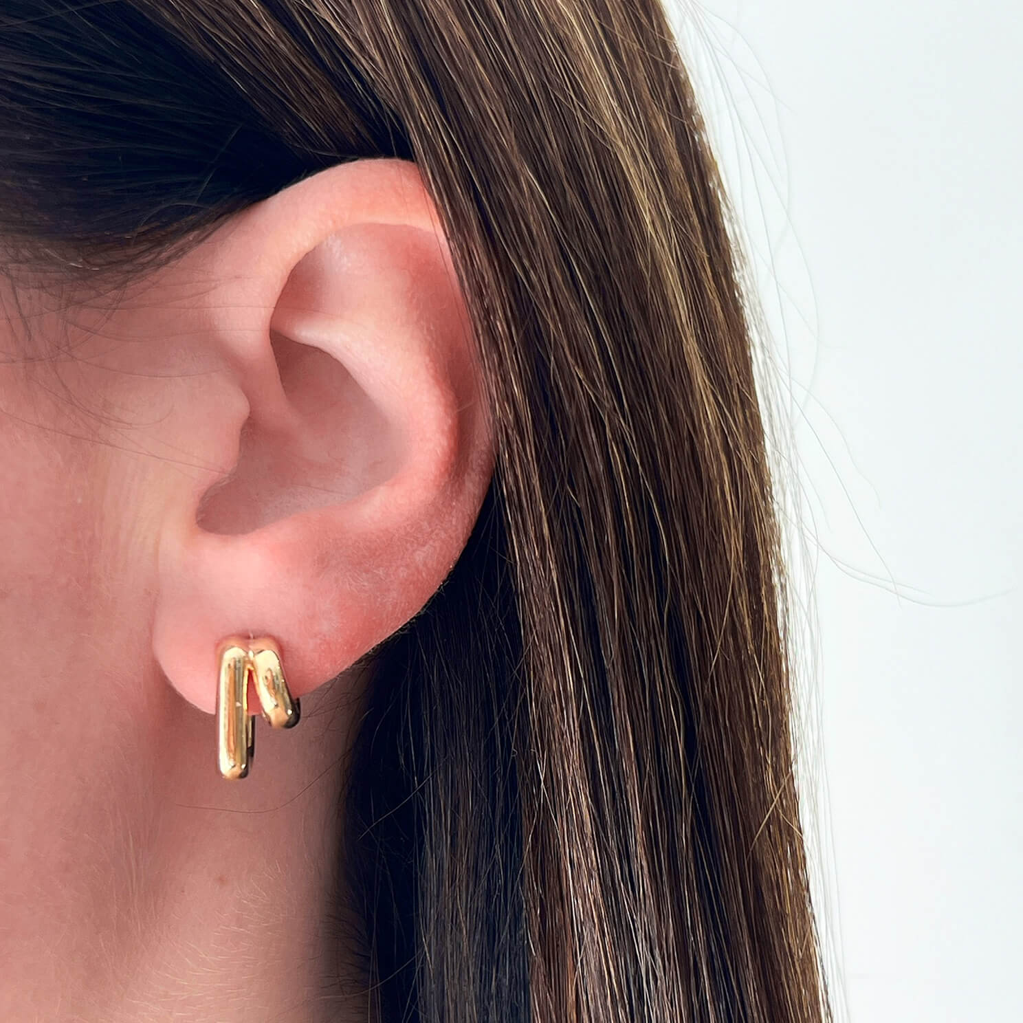 Double Gold Jumbo Huggie Earring in 14k yellow gold styled on ear lobe of model