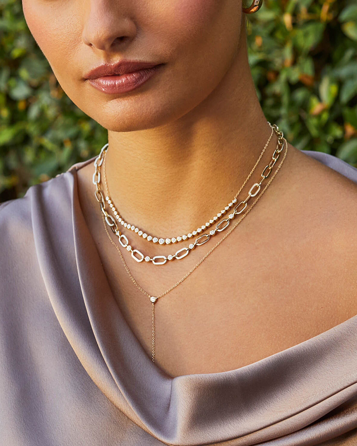 Graduated Diamond Pillow Necklace in 14k yellow gold styled on neck of model with jumbo link diamond pillow necklace and lariat necklace
