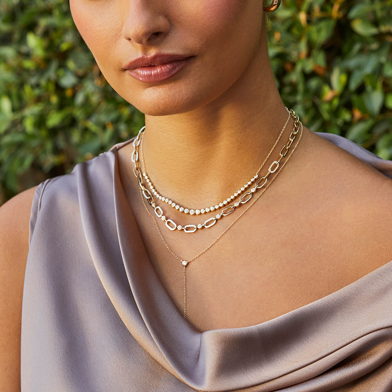 Graduated Diamond Pillow Necklace in 14k yellow gold styled on neck of model with jumbo link diamond pillow necklace and lariat necklace