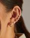Gold Jumbo Dome Hoop Earrings in 14k yellow gold styled on first earring hole of model next to five diamond earrings