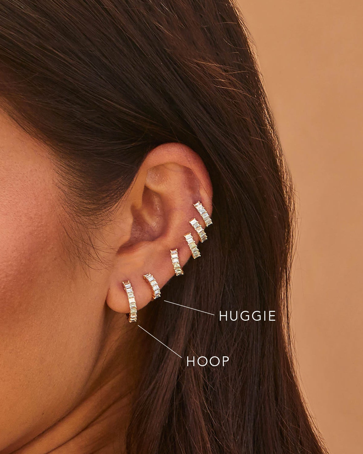 Prong Set Diamond Baguette Hoop Earrings in 14k yellow gold styled on first earring hole of ear of model wearing five prong set diamond baguette huggie earrings