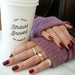 Mauve Cashmere Wrist Warmers styled on model with 14k yellow gold rings with diamonds styled on fingers next to white cup