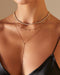 9 Prong Set Diamond Necklace in 14k yellow gold styled on neck of model with diamond tennis necklace and diamond lariat necklace