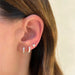 Prong Set Baguette Huggie pair in yellow gold in ear lobe. 