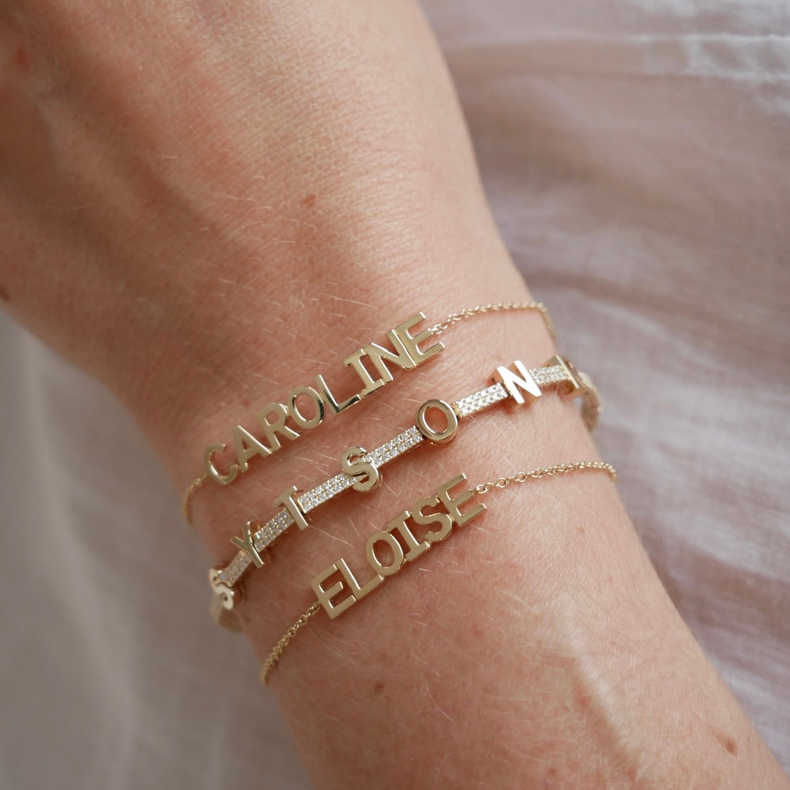 Gold Custom Name Bracelet styled on the wrist in yellow gold