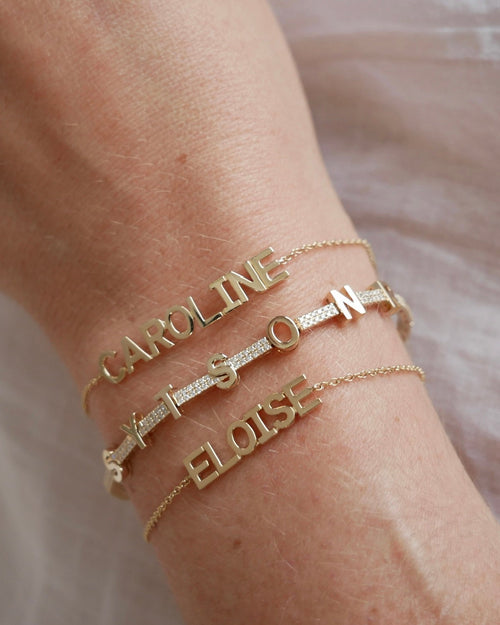 Gold Custom Name Bracelet styled on the wrist in yellow gold