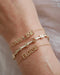 Gold Custom Name Bracelet styled on the wrist in yellow gold