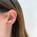 Emerald Mini Huggie earring on the ear in 14k yellow gold
