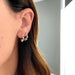 Diamond Teardrop Shimmy Huggie Earring styled on the ear in yellow gold