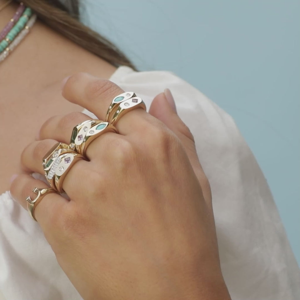 Diamond and Emerald Treasure Ring styled on ring and middle finger of model wearing eight additional gold rings on fingers to style with no audio