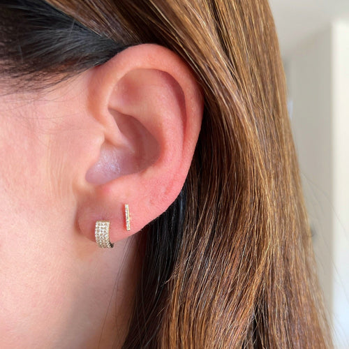 Diamond Jumbo Huggie earring on the ear in yellow gold