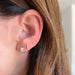 Diamond Jumbo Huggie earring on the ear in yellow gold