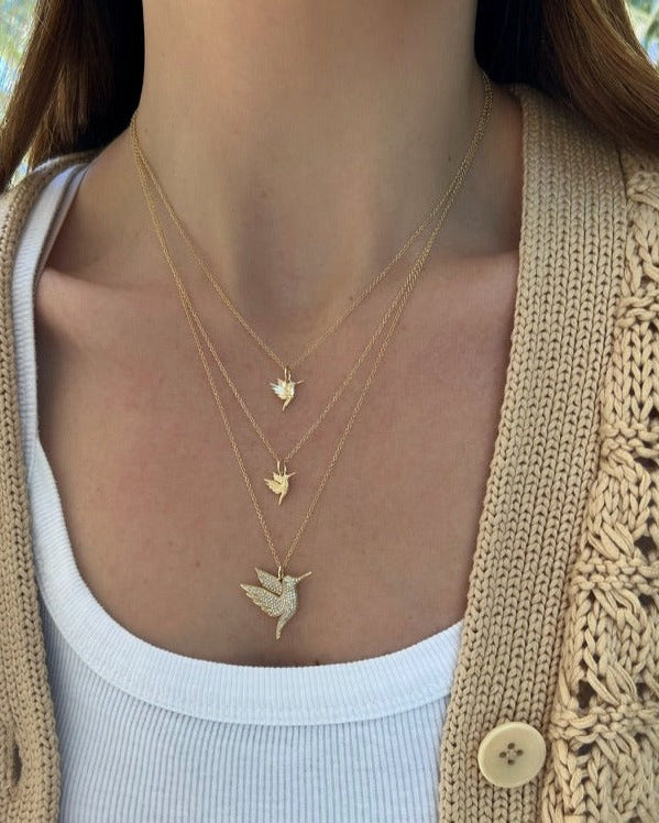 yellow gold hummingbird necklace with diamond eye styled on the neck
