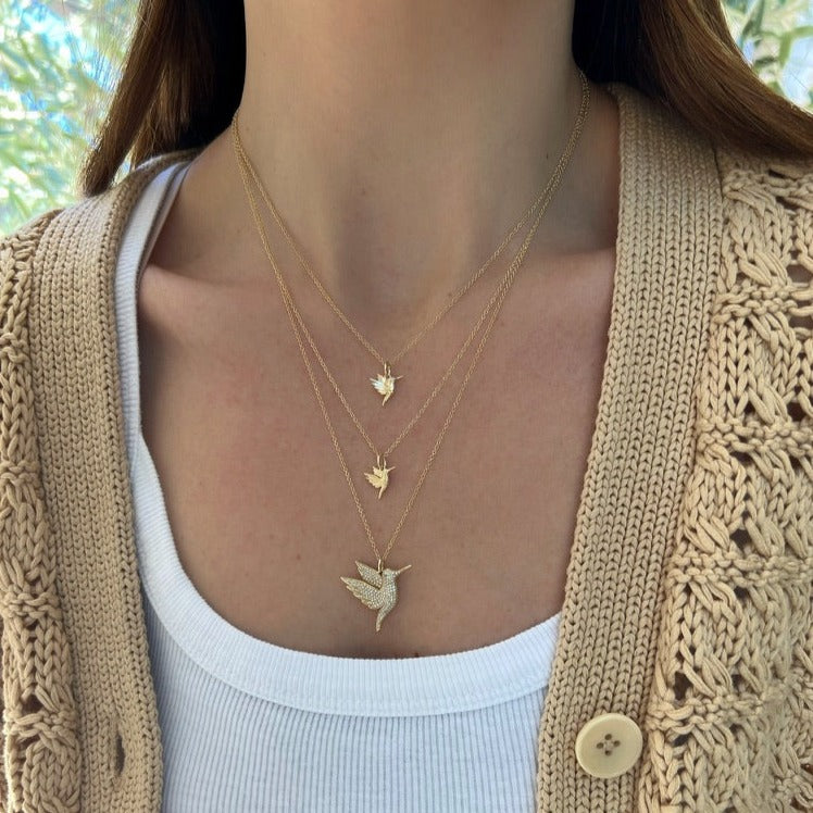 yellow gold hummingbird necklace with diamond eye styled on the neck