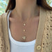 yellow gold hummingbird necklace with diamond eye styled on the neck