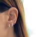 Jumbo Prong Set Diamond Mini Huggie Earring Styled on Ear With Additional Earrings to Show Styling Option