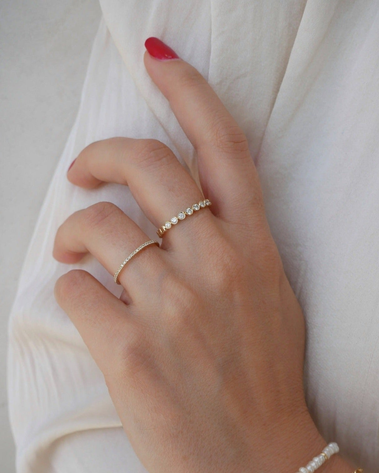 Diamond Eternity Band Ring in 14k Yellow gold styled on ring finger of model wearing white shirt