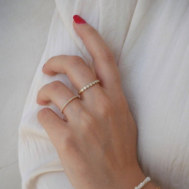 Diamond Eternity Band Ring in 14k Yellow gold styled on ring finger of model wearing white shirt