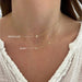 Baby Diamond Star And Gold Moon Necklace in 14k yellow gold styled on neck of model below the regular star necklace in gold