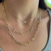 Double Diamond Script Name Necklace in 14k yellow gold with names griffin and zoe styled on neck of model wearing a gold jumbo chain necklace and a heart pendant necklace