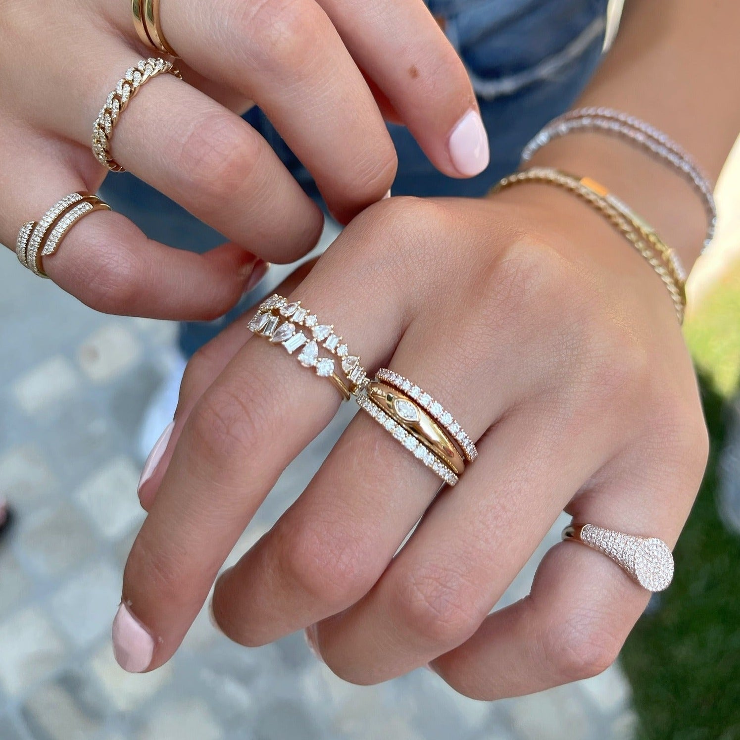 Gold Dome Ring With Diamond Marquise Center in 14k yellow gold styled on finger of model next to stacked diamond and gold rings
