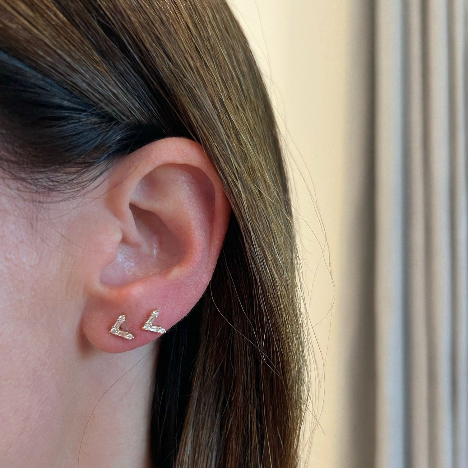 Diamond Baguette Chevron Stud Earring in 14k yellow gold styled on first and second earring hole on earlobe of model