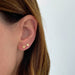 Gold Baby Heart Stud Earrings in 14k yellow gold styled on ear lobe on ear of model