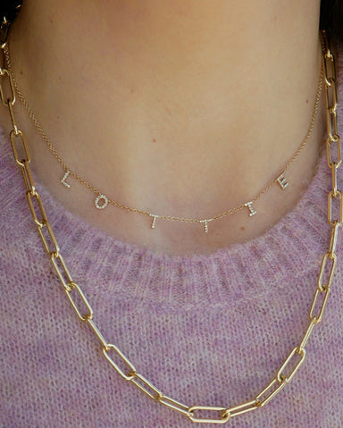 Diamond Multi Initial Necklace in 14k yellow gold styled on neck of model in initials LOTTIE model wearing gold chain and pink sweater