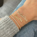 Script Gold Custom Name Bracelet styled on the wrist in yellow gold