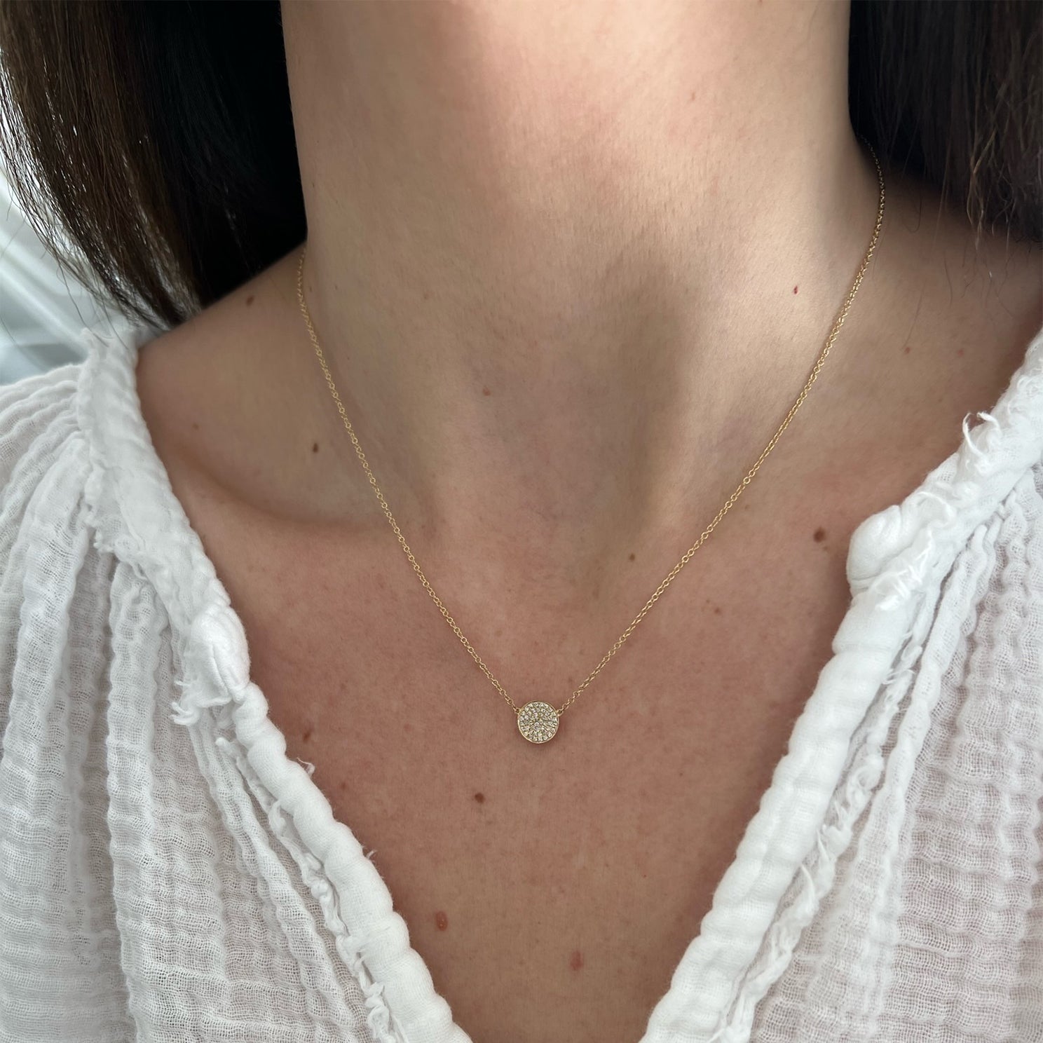 Diamond Disc Necklace in 14k yellow gold styled on neck of model wearing white blouse