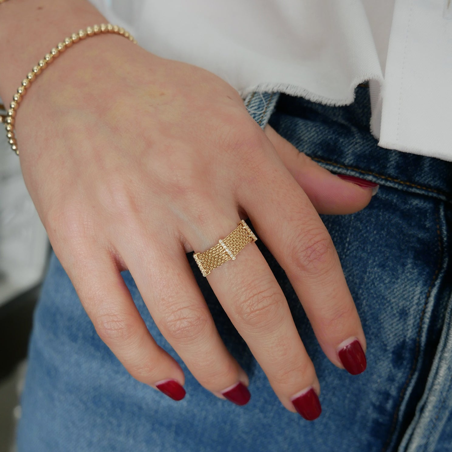 Diamond Bar Mesh Ring in 14k yellow gold styled on middle finger of model wearing denim pants
