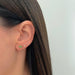 Emerald Wild Palm Stud Earring in 14k yellow gold styled on first earring hole on ear lobe of model next to sparkle stud