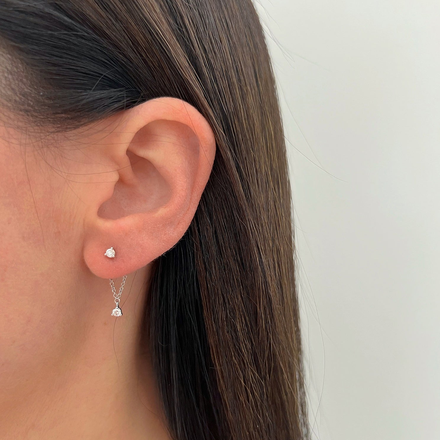 Suspended Diamond Stud Earring in 14k white gold styled on ear lobe of model