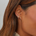 Diamond Baguette Huggie Earrings in 14k yellow gold styled on ear