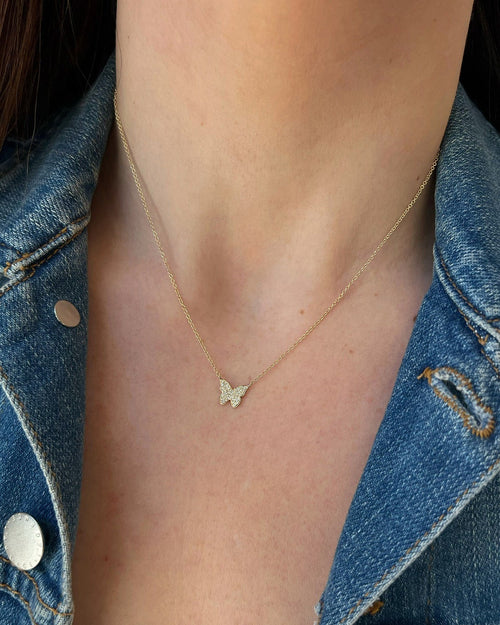 Diamond Butterfly Necklace in 14k yellow gold styled on neck of model wearing denim jacket