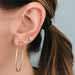 Essential Gold Hoop Earrings in 14k yellow gold styled on ear next to diamond butterfly earrings
