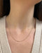 Gold Faceted Ball Chain in 14k yellow gold styled on neck of model wearing tan sweater