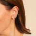Diamond Marley Mini Huggie Earring in 14k yellow gold styled on second earring hole on earlobe of model with three additional piercings