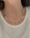 9 Prong Set Diamond Necklace in 14k yellow gold styled on neck of model with diamond and gold necklaces