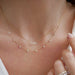Diamond Multifaceted Mini Bar Necklace in 14k yellow gold styled on neck of model with 9 prong diamond necklace