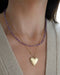 Birthstone Bead Necklace In Amethyst styled on neck of model with gold heart locket necklace and wearing tan sweater