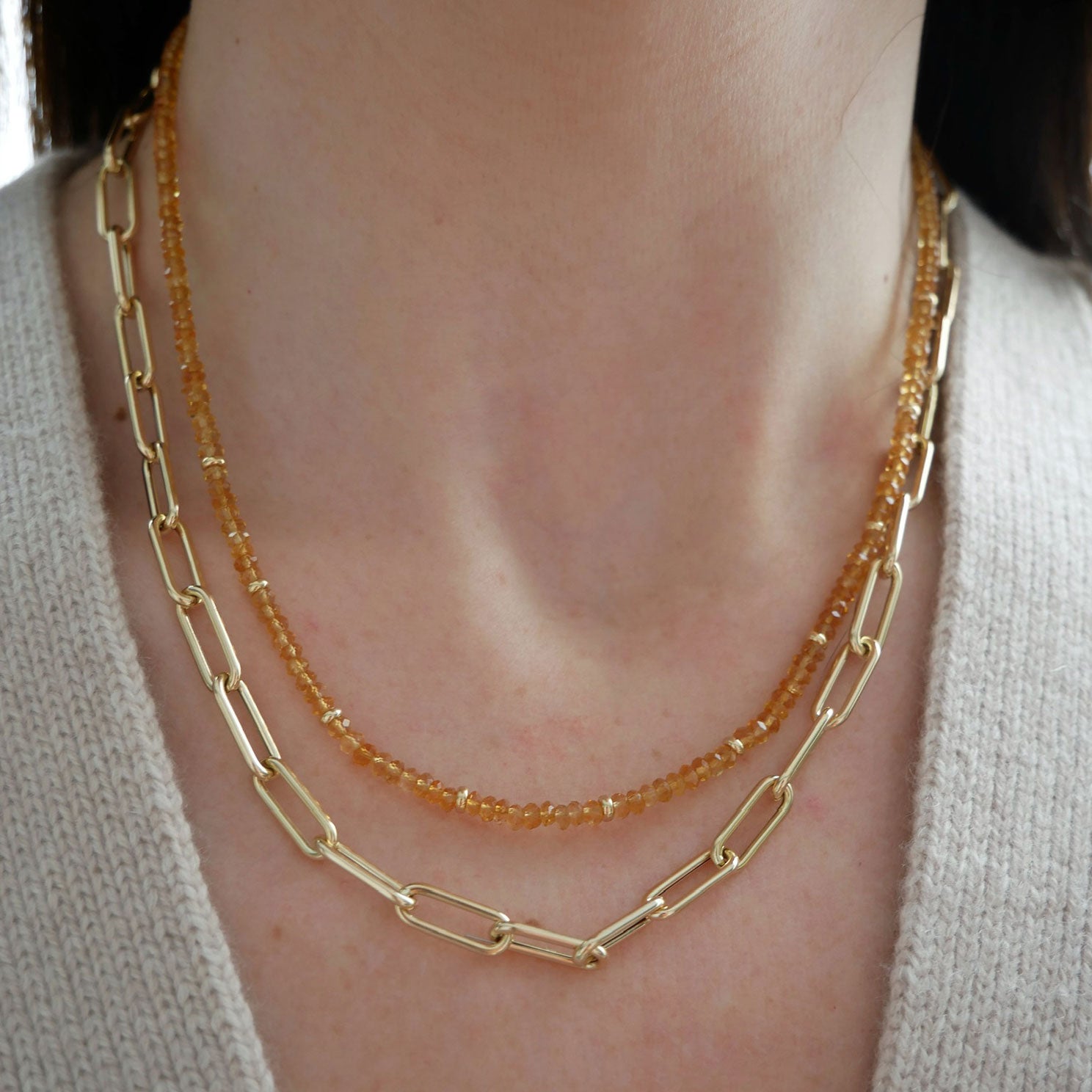 Birthstone Bead Necklace In Citrine styled on neck of model with jumbo lola chain gold necklace and wearing sweater